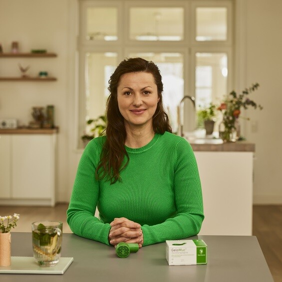 Frau sitzt für die Anwendung des GeloMuc in einer entspannten Haltung