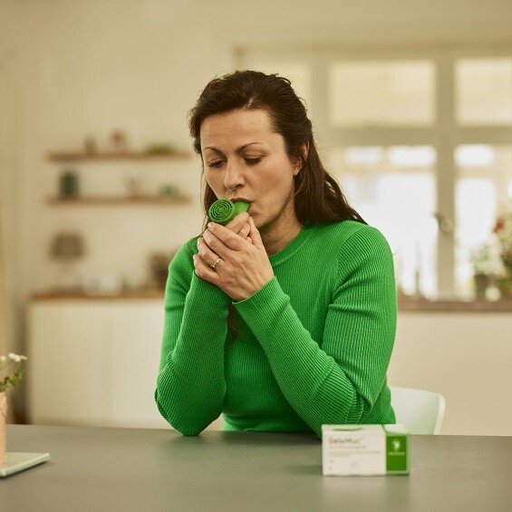 Frau mit chronischem Husten wendet das GeloMuc Atemtherapiegerät an