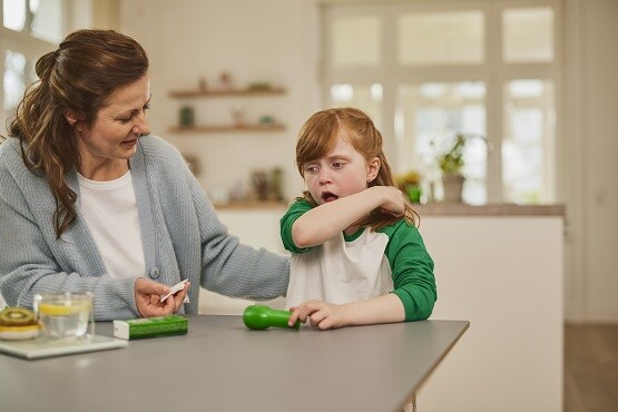 Kind sitzt neben der Mutter und hustet